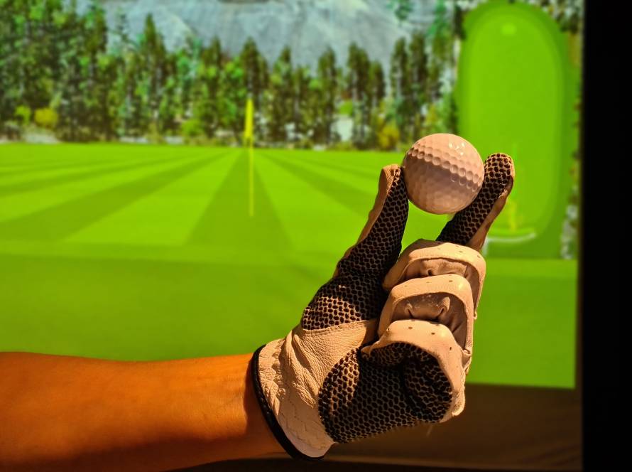 Golfer learning scoring terms like Par, Eagle, and Bogey at Birdie Indoor Golf Center using an indoor golf simulator.