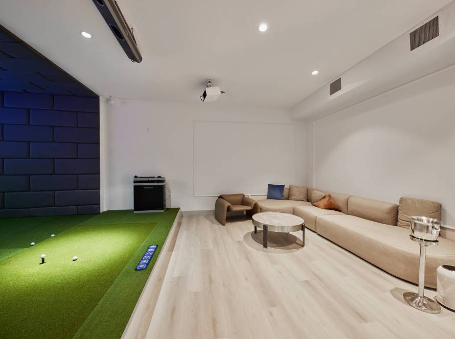 Private VIP indoor golf room with golf simulator, putting green, and lounge seating at Birdie Indoor Golf Center | Birdie Indoor Golf Center